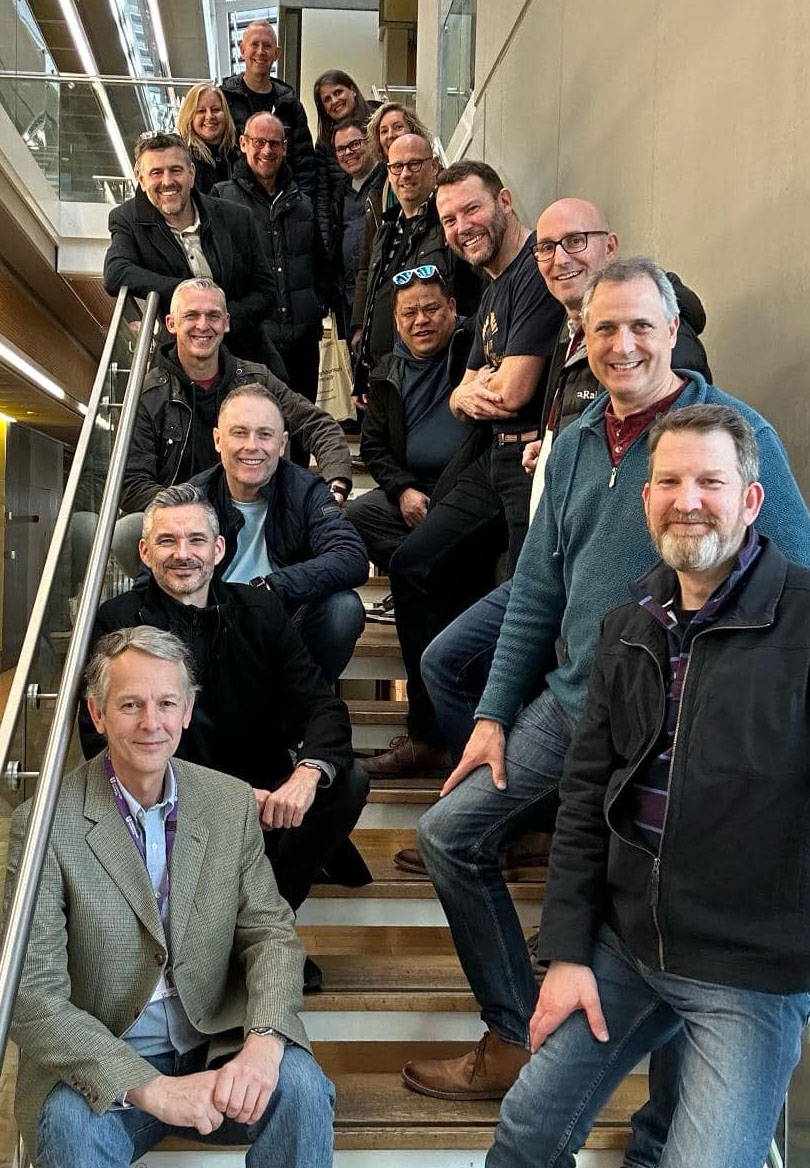 a group of alumni stood on a staircase